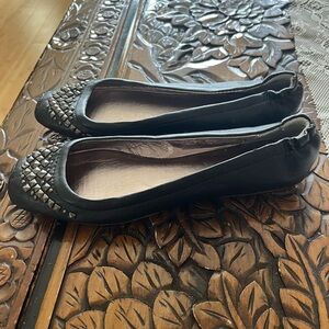 Nine West black leather flats with metal studs.